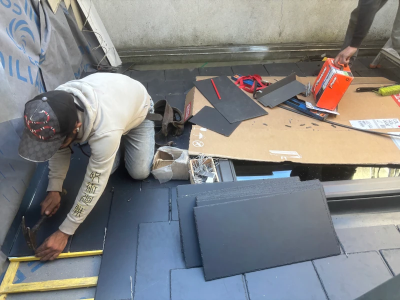 Pose d'ardoises naturelles neuves sur charpente rénovée