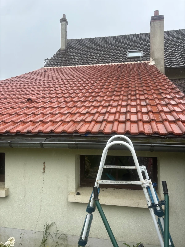 Couvreur posant des tuiles mécaniques neuves sur une toiture rénovée à Artigues-près-Bordeaux